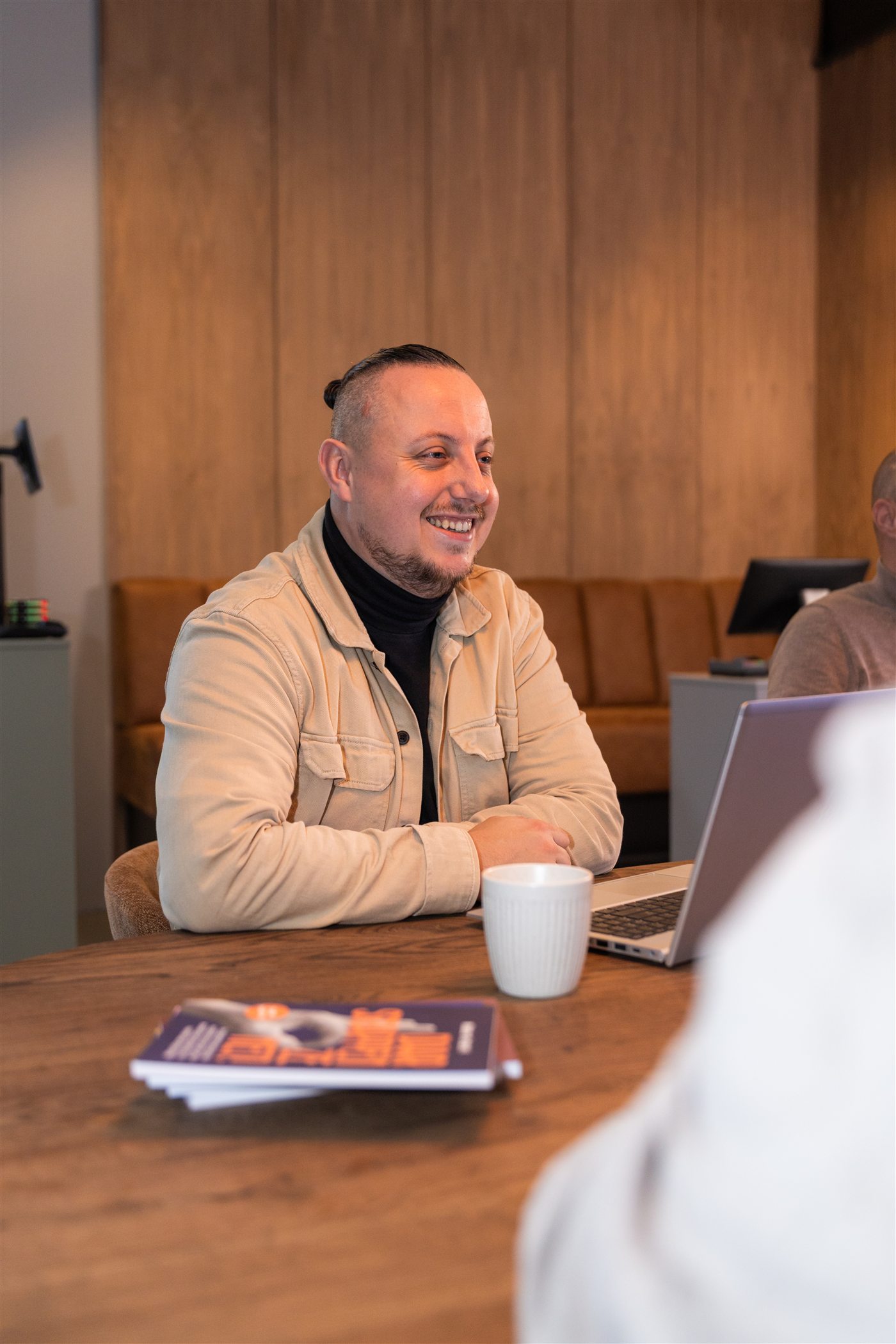 Jero in gesprek aan tafel met zijn laptop